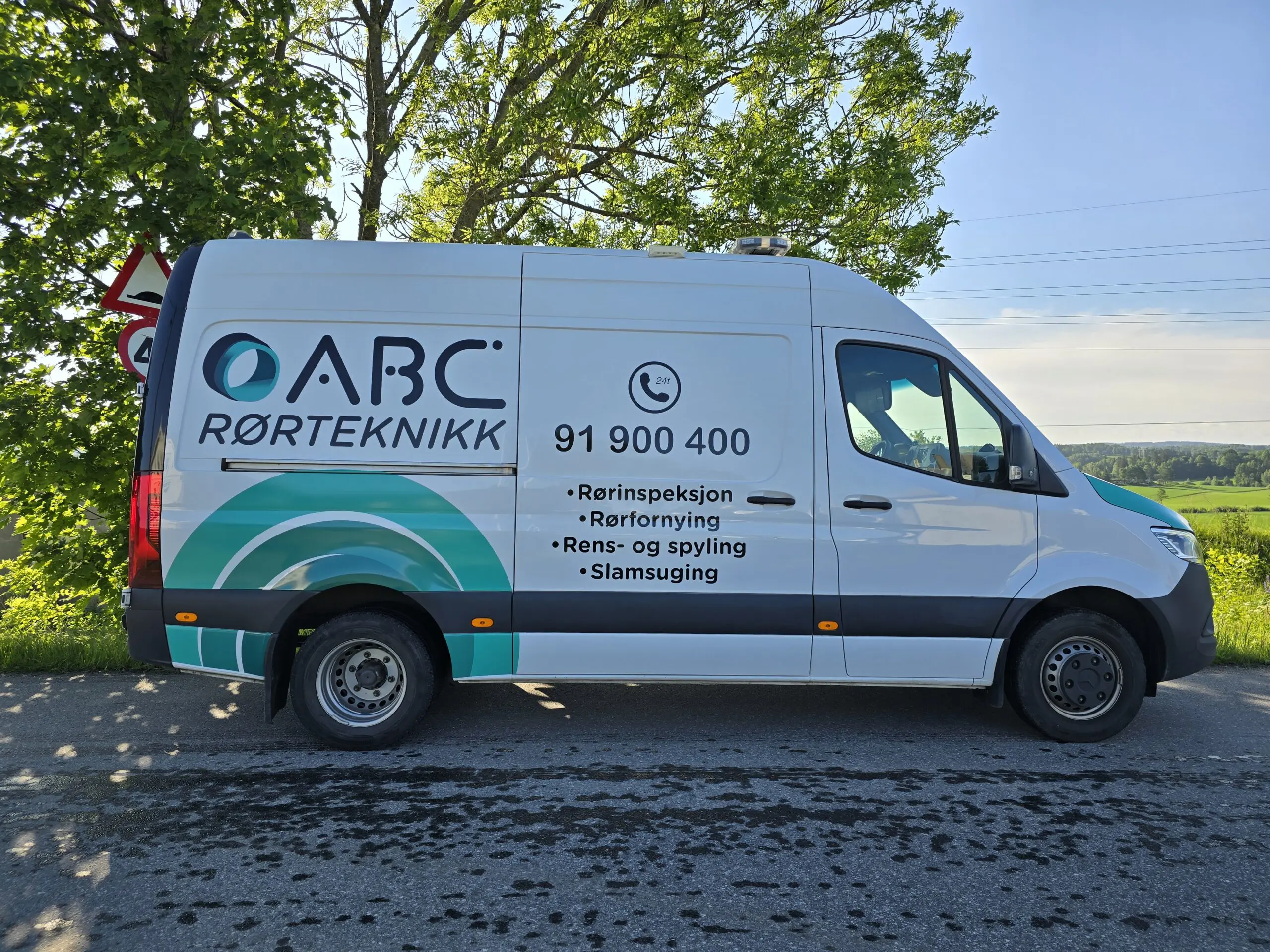 Servicebil fra ABC Rørteknikk parkert langs en allé